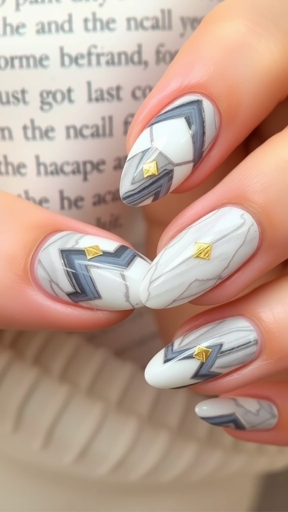 A close-up of beautifully designed marble effect almond nails featuring gray and white patterns with gold accents.